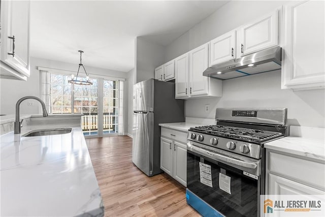 kitchen featuring under cabinet range hood, stainless steel appliances, white cabinets, and a sink