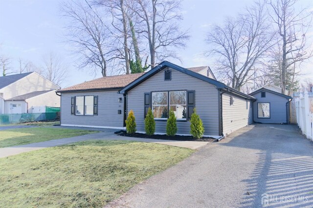 view of front of house with an outdoor structure and a front yard