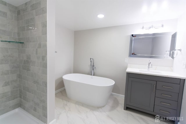 full bathroom featuring marble finish floor, a tile shower, vanity, a freestanding tub, and recessed lighting