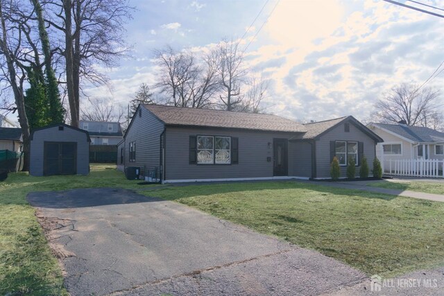 single story home with a shed and a front yard