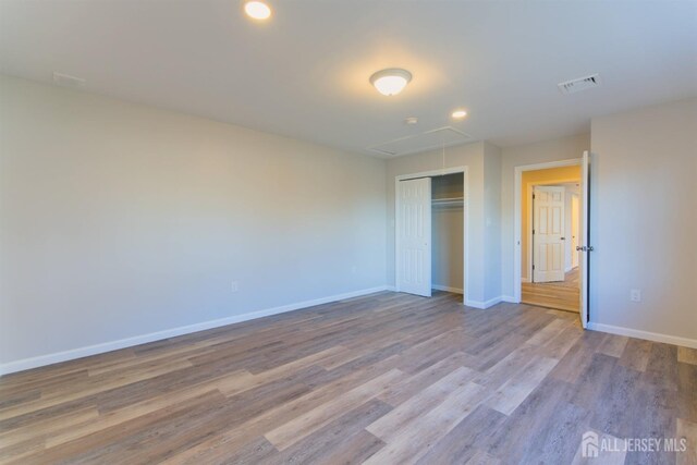 unfurnished bedroom featuring light wood-type flooring and a closet