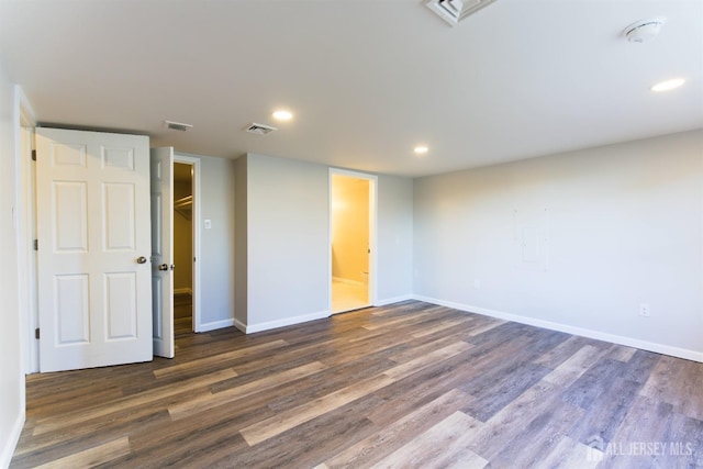 unfurnished room featuring dark wood-style floors, visible vents, and baseboards