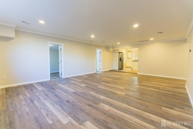 spare room with baseboards, visible vents, wood finished floors, and recessed lighting