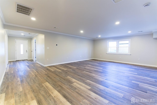 empty room featuring baseboards, visible vents, and wood finished floors