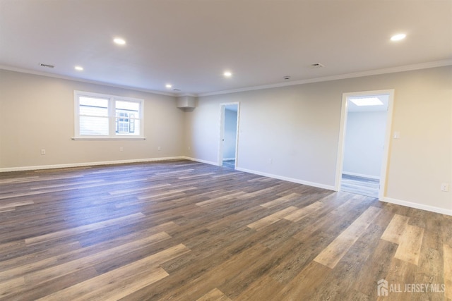 empty room with crown molding, baseboards, and dark wood-type flooring