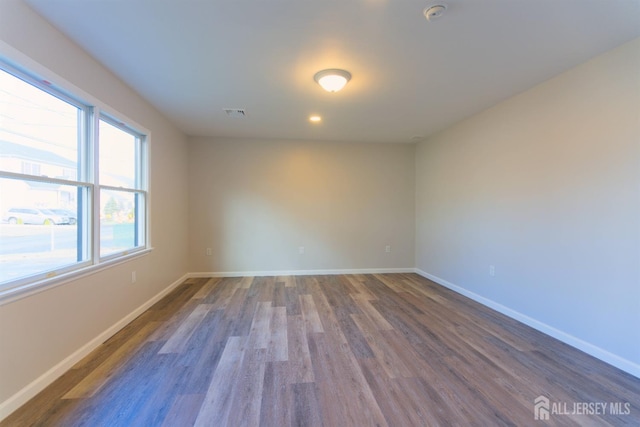 empty room featuring baseboards and wood finished floors