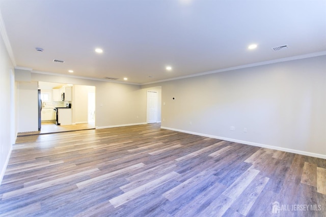 unfurnished room with ornamental molding, light wood-style flooring, visible vents, and baseboards