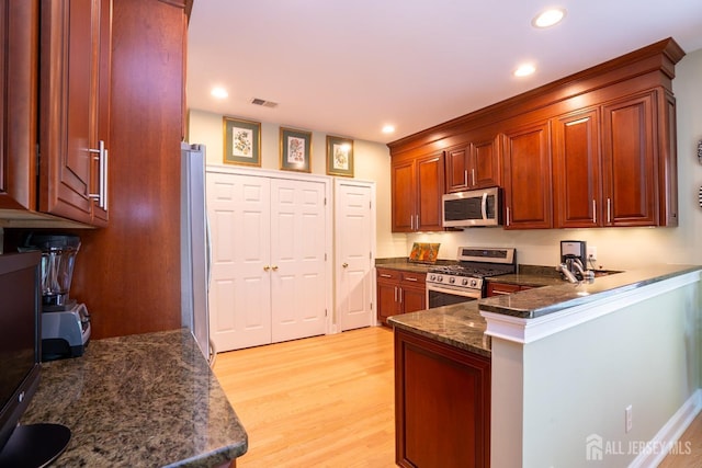 16 Baltusrol Ct, Monroe, NJ 08831 - kitchen featuring appliances with stainless steel finishes, light wood-type flooring, a peninsula, recessed lighting, and dark stone counters