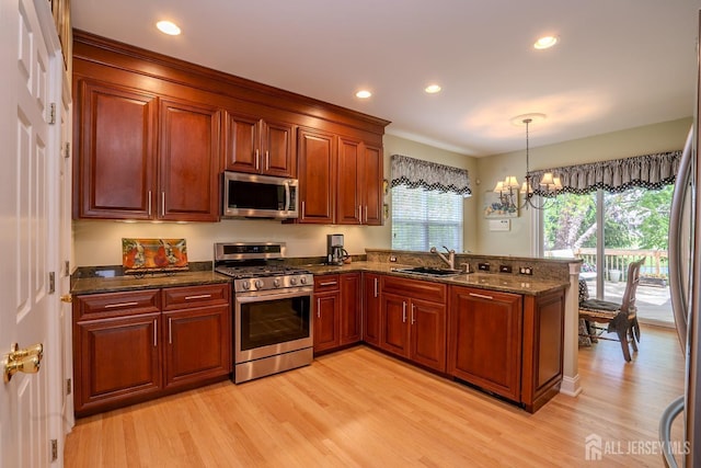 16 Baltusrol Ct, Monroe, NJ 08831 - kitchen with stainless steel appliances, a sink, light wood-style floors, a peninsula, and a chandelier