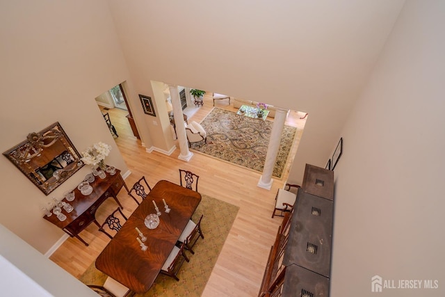 16 Baltusrol Ct, Monroe, NJ 08831 - living area featuring ornate columns, a towering ceiling, light wood-style flooring, and baseboards