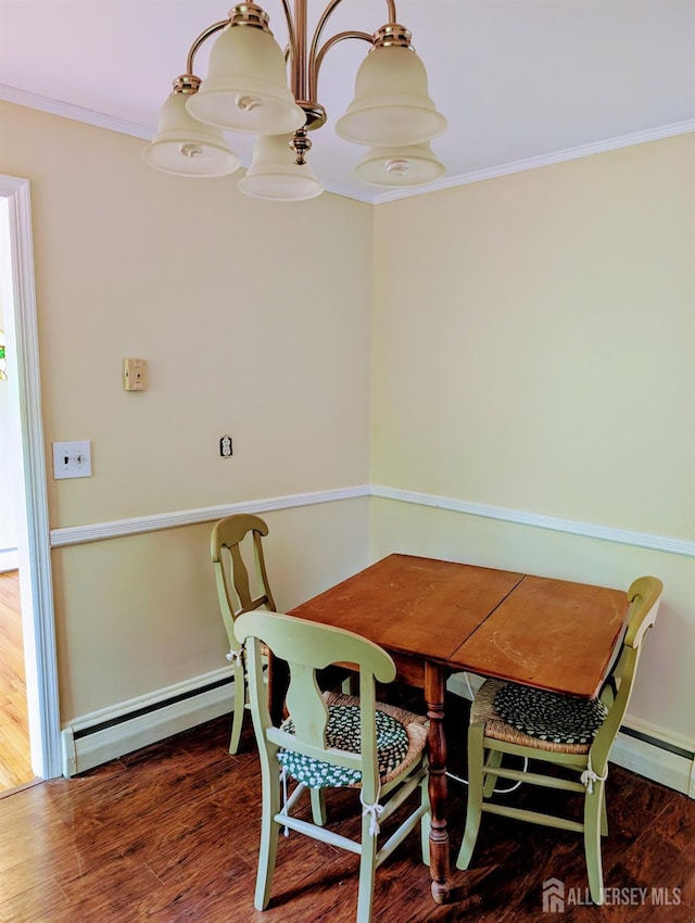 dining space with ornamental molding, a baseboard radiator, and wood finished floors