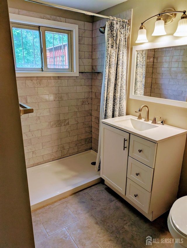 full bathroom featuring a shower stall, toilet, vanity, and tile patterned floors
