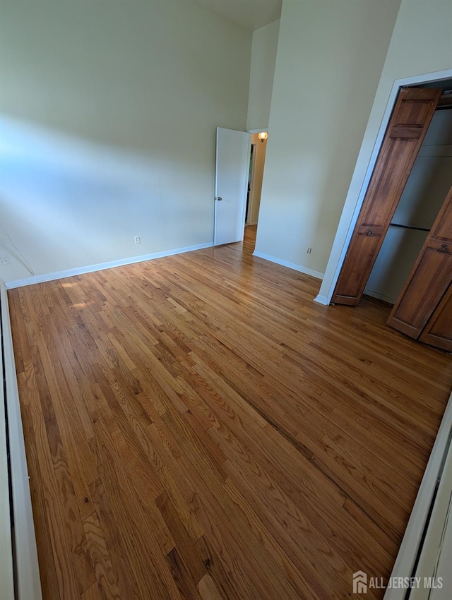 unfurnished bedroom featuring wood finished floors and baseboards