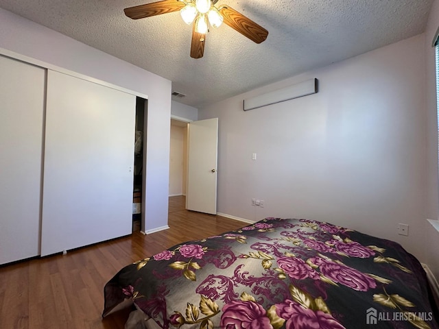 bedroom featuring visible vents, a ceiling fan, dark wood-style flooring, a textured ceiling, and a closet