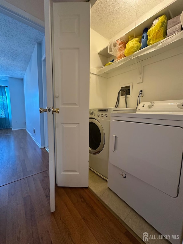 washroom featuring dark wood finished floors, a textured ceiling, separate washer and dryer, laundry area, and baseboards