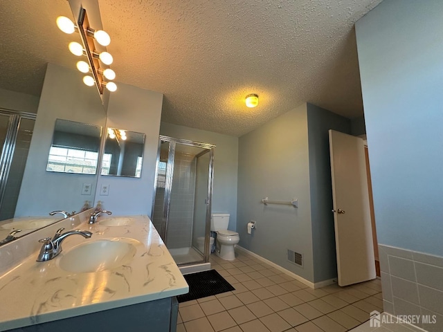 bathroom featuring visible vents, toilet, tile patterned flooring, a textured ceiling, and a sink