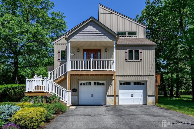 22 Roosevelt St, Pequannock, NJ 07440 - view of front of property featuring board and batten siding, covered porch, driveway, stairway, and a garage