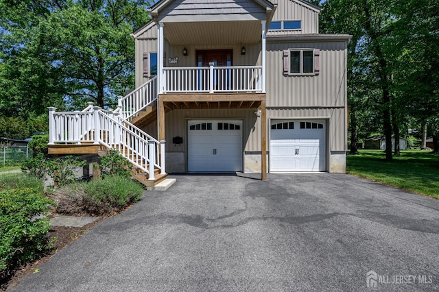 22 Roosevelt St, Pequannock, NJ 07440 - view of front of property with driveway, board and batten siding, a garage, and stairway