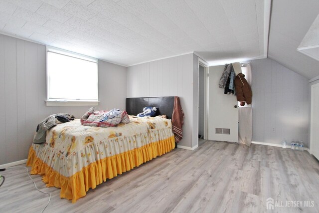 bedroom with lofted ceiling and light hardwood / wood-style flooring