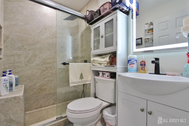 bathroom with an enclosed shower, vanity, and toilet