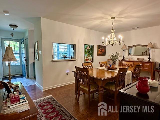 271 Constitution Cir, North Brunswick, NJ 08902 - dining space with a chandelier, wood finished floors, and baseboards