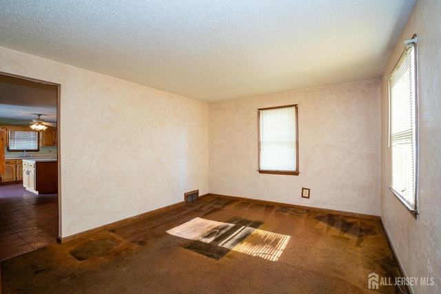 carpeted empty room featuring a textured ceiling