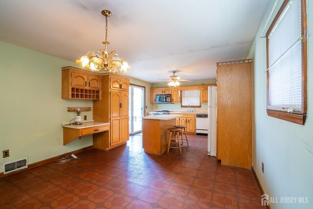 kitchen featuring a breakfast bar, sink, decorative light fixtures, a center island, and white dishwasher