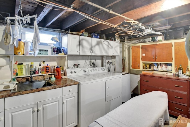 clothes washing area featuring washing machine and dryer and cabinet space