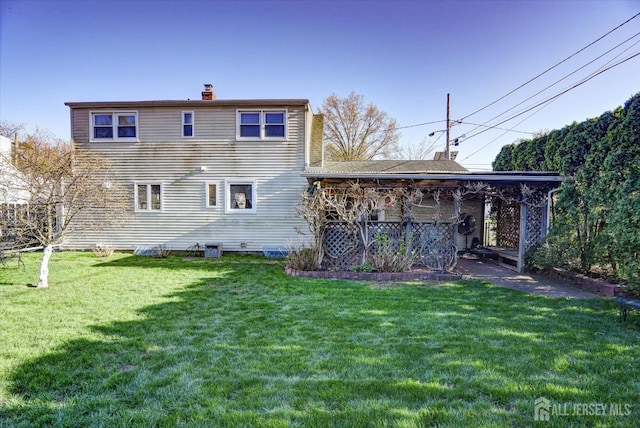 rear view of property featuring a chimney and a yard