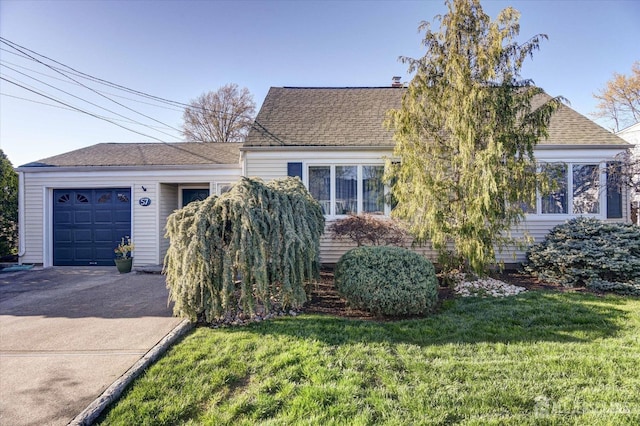 view of front of home with an attached garage, a front yard, asphalt driveway, and a shingled roof