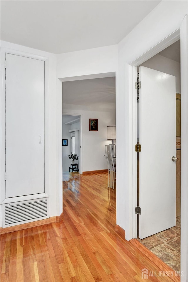 hallway with light wood-style flooring and baseboards