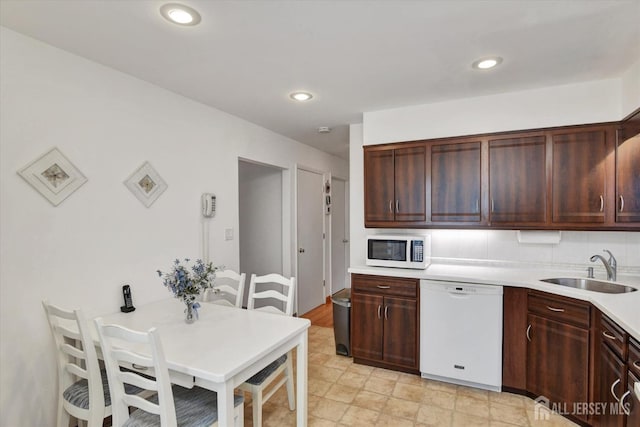 kitchen with white appliances, a sink, light countertops, recessed lighting, and dark brown cabinetry