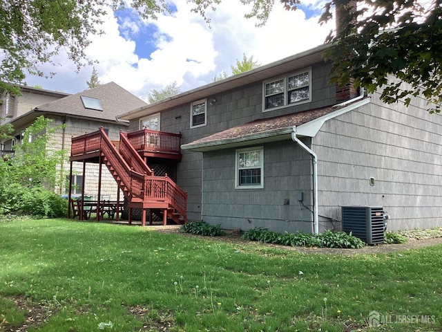 rear view of house with stairway, central air condition unit, a deck, and a lawn