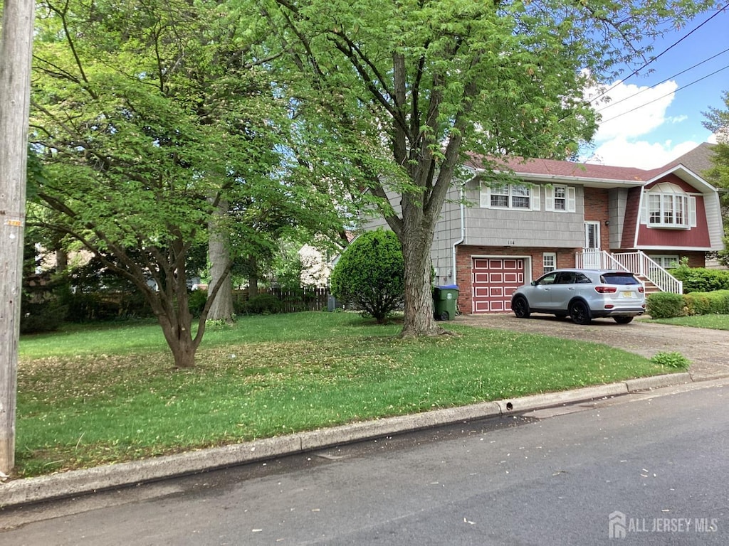 view of front of home featuring asphalt driveway, brick siding, a garage, and a front yard