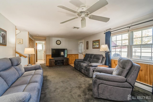 1430 Seneca Rd, North Brunswick, NJ 08902 - carpeted living room featuring a wainscoted wall, wood walls, a baseboard radiator, and ceiling fan