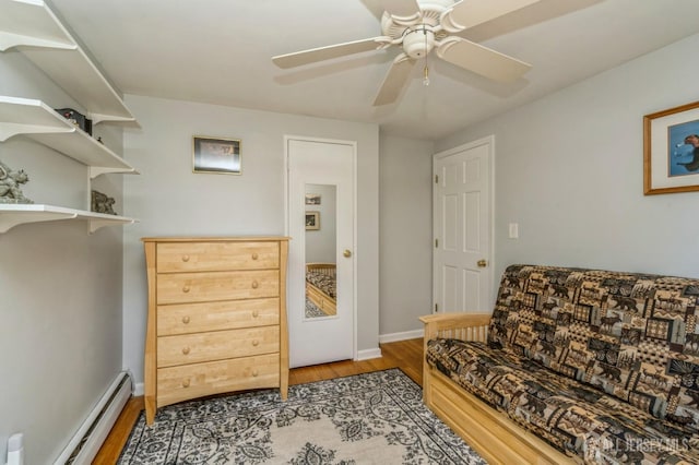 sitting room with light wood-type flooring, a baseboard radiator, baseboards, and ceiling fan