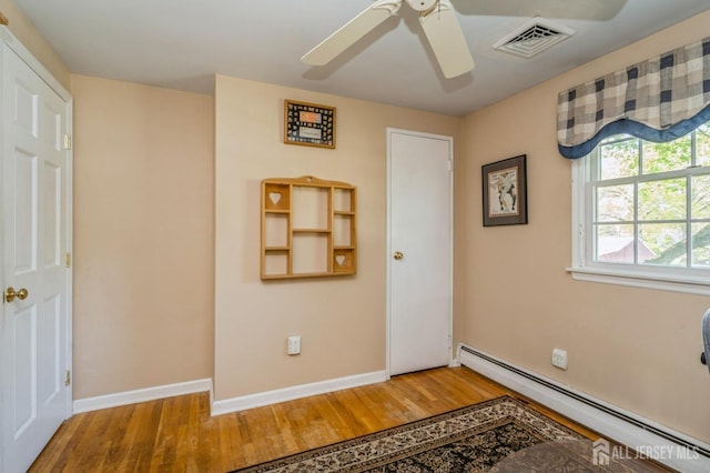 1430 Seneca Rd, North Brunswick, NJ 08902 - unfurnished bedroom with a baseboard radiator, wood finished floors, baseboards, and a ceiling fan