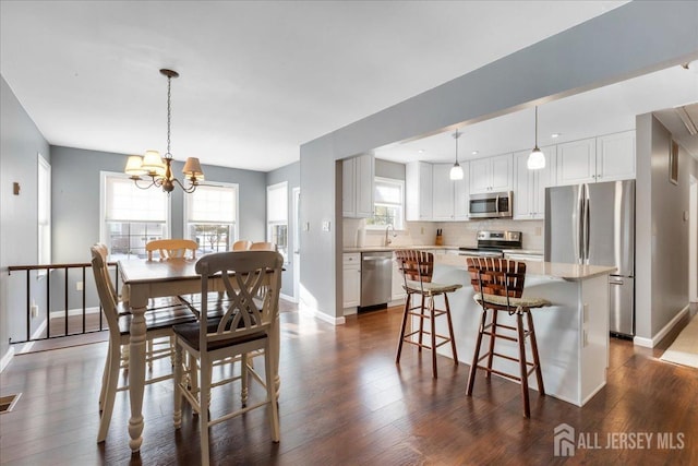 dining area with a chandelier, visible vents, dark wood finished floors, and baseboards