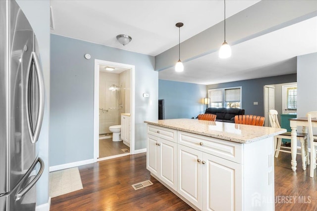 kitchen featuring white cabinets, dark wood-style floors, freestanding refrigerator, and decorative light fixtures