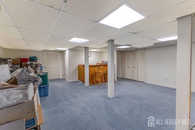 basement with indoor bar, carpet floors, and a drop ceiling