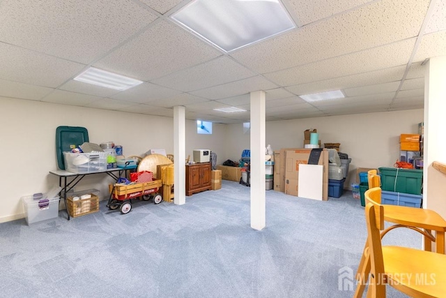 basement with carpet and a paneled ceiling