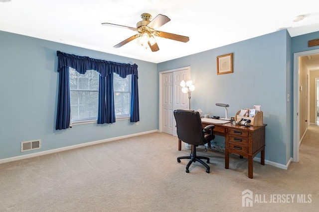 carpeted home office featuring ceiling fan