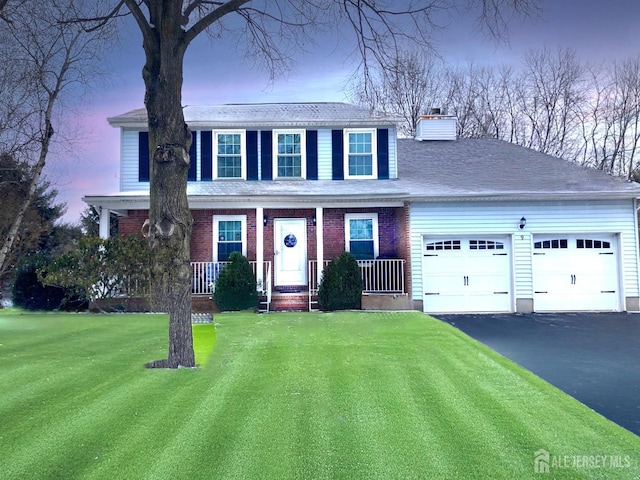 view of front of house with a garage and a lawn