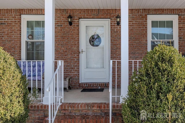 doorway to property featuring brick siding