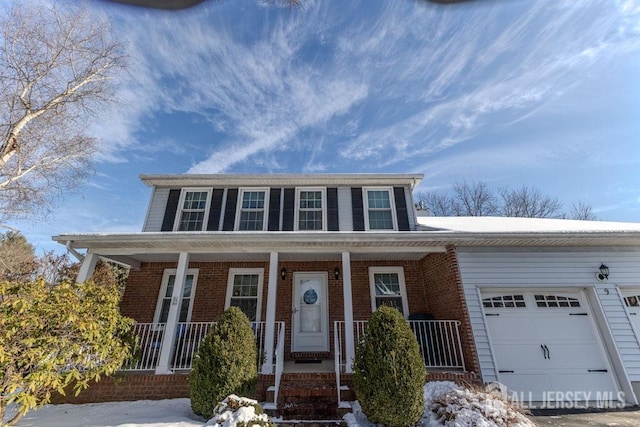 view of front of home with a garage, a porch, and brick siding