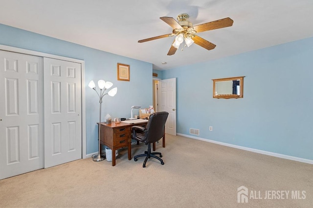 carpeted office space featuring ceiling fan