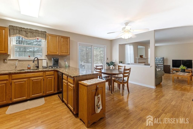 kitchen featuring tasteful backsplash, sink, light hardwood / wood-style floors, and kitchen peninsula