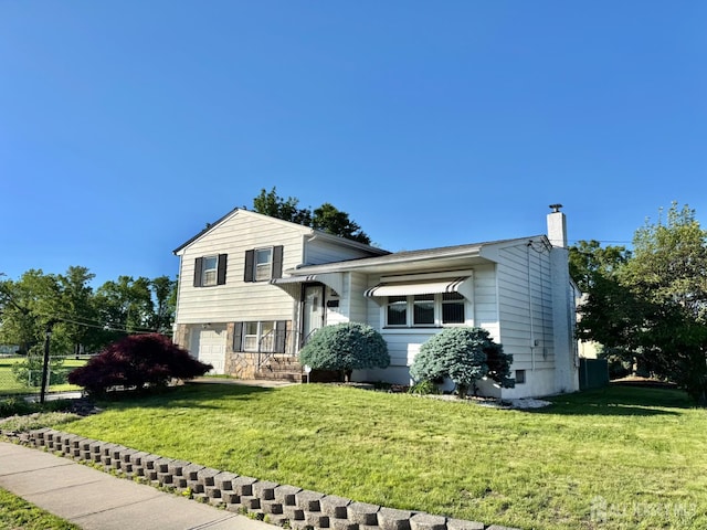 split level home featuring a front lawn, a chimney, an attached garage, and stone siding