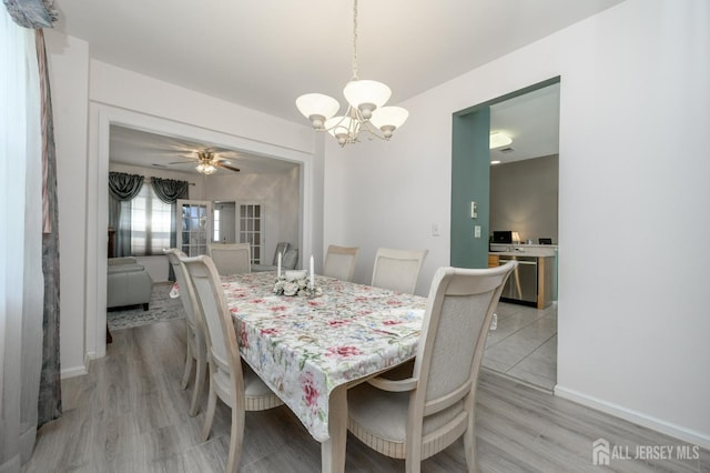 dining space with a chandelier, light wood-style floors, and baseboards