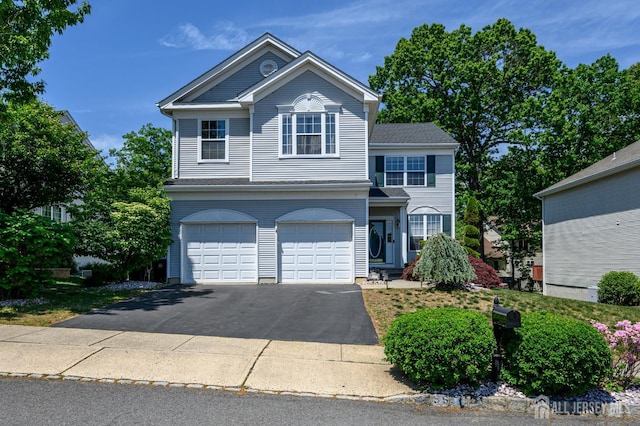 traditional-style house with a garage and asphalt driveway